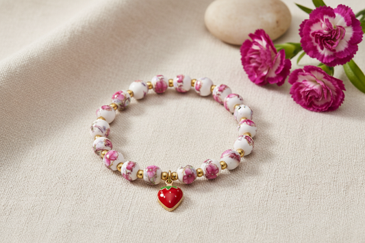 Bracelet with floral beads and strawberry charm on a white background